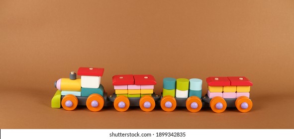 Close Up One Wooden Painted Colorful Toy Train On Background Of Brown Paper, High Angle, Side View