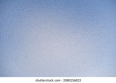 Close Up Of Opaque Frosted Glass Against A Blue Sky