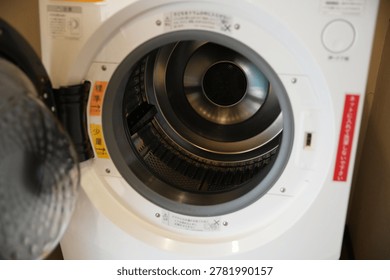 Close up of an open empty washing machine drum.