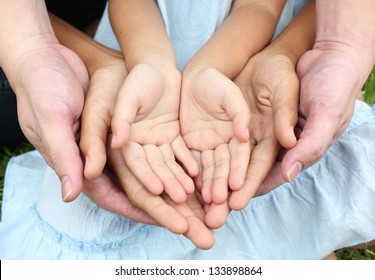 Close Up Open Hands Of Man And Woman And Kid With Palm Up Isolated On Green Grass Background. Family Together Helping Green Environment Protection Harmony Community And Caring Concept 