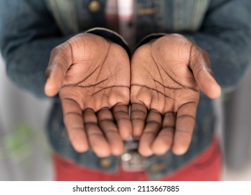 Close up open hands of a young african american man wearing denim jacket. Begging hands of a poor man concept. Young african american man with outstretched hands begging for money for life.