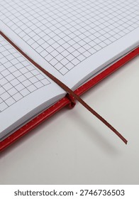 Close up of an open squared notebook with a ribbon bookmark