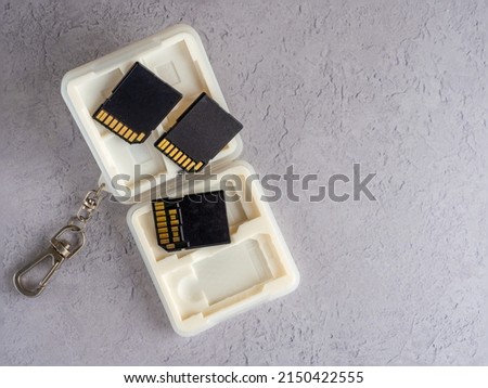 close up of an open  white  memory card case with soft moulded insert for SD and CFexpress cards with key chain