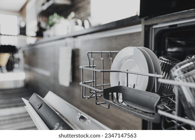Close up of opened automatic stainless built-in dishwasher machine inside modern home kitchen with clean utensil. Household, housekeeping domestic life. Opening and closing washing machine - Shutterstock ID 2347147563