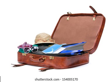 Close up of opened brown suitcase with clothing for traveling, isolated on white