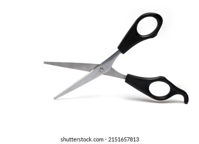 Close up of opened pointed sharp hairdresser coiffure beard scissors for cutting hair with black handle and finger rest on white background