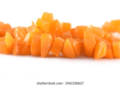 Close up of orange Beads on the white background, unshaped beads, Background or texture of beads. macro,used in finishing fashion clothes. make bead necklace or string of beads for woman of fashion.