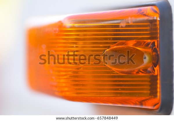 Close up orange direction\
indicator on car or other vehicle, with pattern and texture, copy\
space.