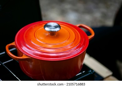 Close Up Of Orange Enameled Cast Iron Dutch Oven Camping Stove