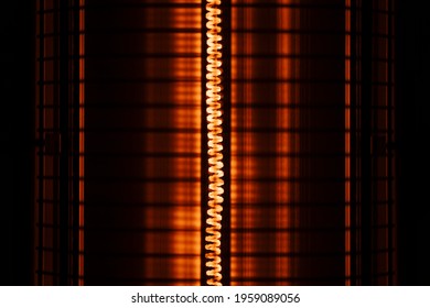 Close Up Of An Orange Red Electric Heater Coil With Grill Protection