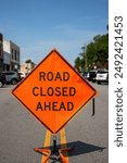 Close up of an orange road closed sign blocking off a street 