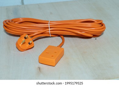 close up of an orange single UK 13 amp single socket thirty foot extension lead suitable to connect power tools and back yard equipment waterproof