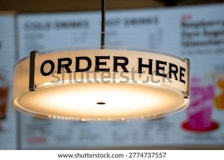 Close up of Order Here sign inside cafe counter area.
