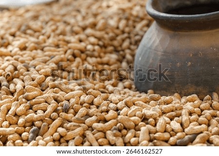 Close up of organic peanuts in shell with rustic pottery representing farm harvest and traditional agricultural production