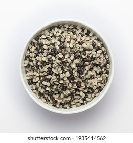 Close up of Organic split black urad dal (Vigna mungo) with shell on a ceramic white bowl. Top view 