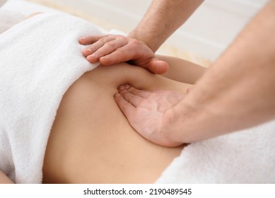 Close up of osteopath doing manipulative massage on woman abdomen on white background, copy space - Shutterstock ID 2190489545