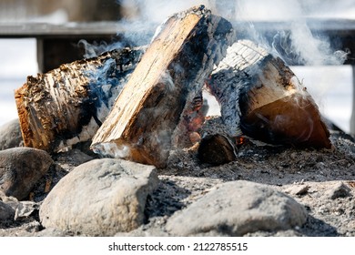 Close Up Of An Outdoor Fire Pit With Burning Embers And Smoke During Winter