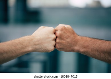 Close Up Outdoor Photo Of Two Men's Fists Holding Together