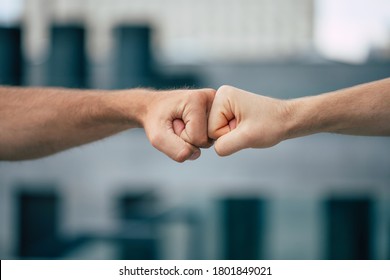 Close Up Outdoor Photo Of Two Men's Fists Holding Together