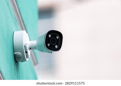 Close up of outdoor security camera mounted on building wall. Surveillance, safety, monitoring and smart home protection concept with copy space.