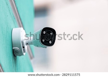 Close up of outdoor security camera mounted on building wall. Surveillance, safety, monitoring and smart home protection concept with copy space.