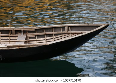 Close up outdoor view from above of part of a small wooden boat on the water. Particular design with wooden strips at the interior of the canoe. Curved shapes with clear brown lines. Abstract image.   - Powered by Shutterstock