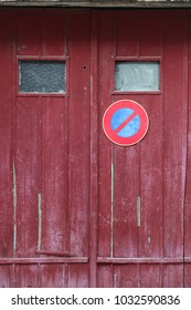 Close up outdoor view of an old wooden garage door with the symbol no parking. Small windows, purple planks with the circular sign in blue and red. Rough vintage texture. Abstract architectural image. - Shutterstock ID 1032590836