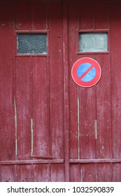 Close up outdoor view of an old wooden garage door with the symbol no parking. Small windows, purple planks with the circular sign in blue and red. Rough vintage texture. Abstract architectural image. - Shutterstock ID 1032590839