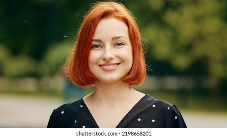 Close Up Outdoors Portrait Of Human Female Face Caucasian Young Girl Redhead Woman Lady Smiling Outside Nodding Head Yes Answers Approval Sign Agree Positive Agreement Approval Support Posing Flirting