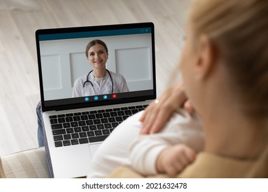 Close Up Over Shoulder View Of Young Caucasian Mother Talk Speak With Doctor On Computer On Video Call. Mom Have Webcam Digital Virtual Online Communication On Laptop With Family Pediatrician.