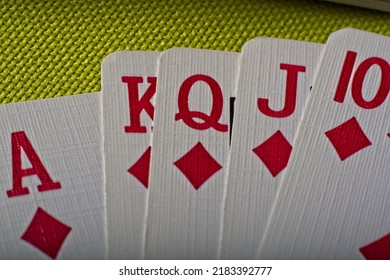 Close Up Overhead View Of Playing Cards Showing Straight Flush Poker Hand On Green Table Top