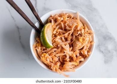 Close Up Of A Pad Thai Bowl With Chopsticks On A White Background.