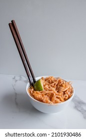 Close Up Of A Pad Thai Bowl With Chopsticks On A White Background.