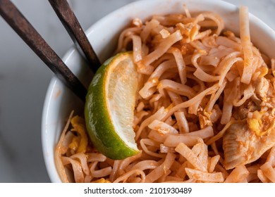 Close Up Of A Pad Thai Bowl With Chopsticks On A White Background.