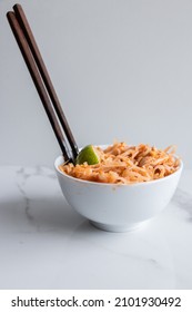 Close Up Of A Pad Thai Bowl With Chopsticks On A White Background.