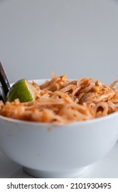 Close Up Of A Pad Thai Bowl With Chopsticks On A White Background.