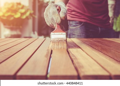Close up paintbrush in hand and painting on the wooden table. Retro and vintage style - Shutterstock ID 440848411