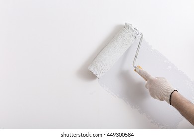 Close Up Of Painter Arm Painting A Wall With Paint Roller