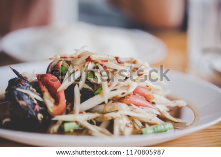 Close up papaya salad in a plate on a table, Thai food is spicy.