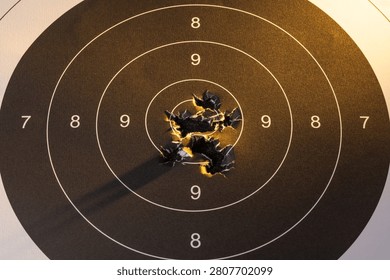 Close up of paper shooting target with multiple bullet holes in the bullseye center, concept for accuracy success perfection and achieving business goals.