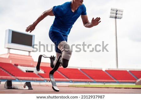 Close up of para-athletes disabled with prosthetic blades run at stadium. Attractive amputee male runner exercise and practicing workout for Paralympics competition regardless of physical limitations.