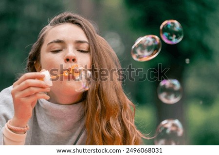 Similar – Image, Stock Photo Young teenage girl blowing pink bubble gum