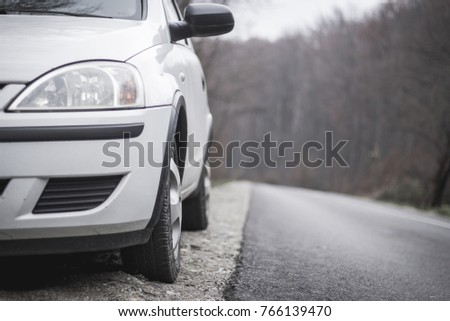 Close up to a parked white car on the side of the road
