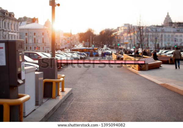 Close up of parking ticket\
machine and barrier gate at the entrance of parking area. Blurred\
concept view of modern europe cityscape. Business center of old\
town. 
