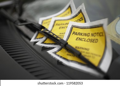 Close up of parking ticket placed under windshield wiper of a car