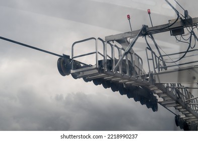 Close Up Of Part Of Overhead Cable Car Against Cloudy Sky