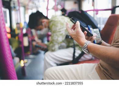 Close Up Passenger Using Phone Inside The City Bus Singapore. Public Transport In The City Singapore.