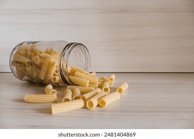 Close up of pasta in a glass jar on a white wooden table.  - Powered by Shutterstock