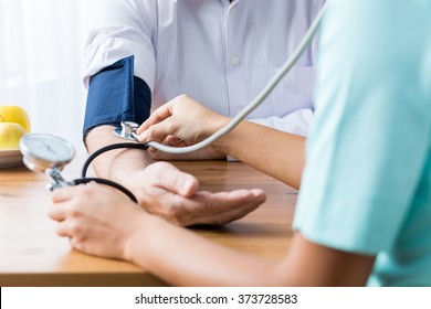 Close Up Of Patient And Doctor Taking Blood Pressure