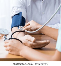 Close Up Of Patient And Doctor Taking Blood Pressure